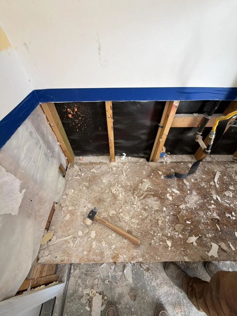 Wall opened to the studs with debris across the subfloor, lead abatement from Apex Home Services in Las Vegas